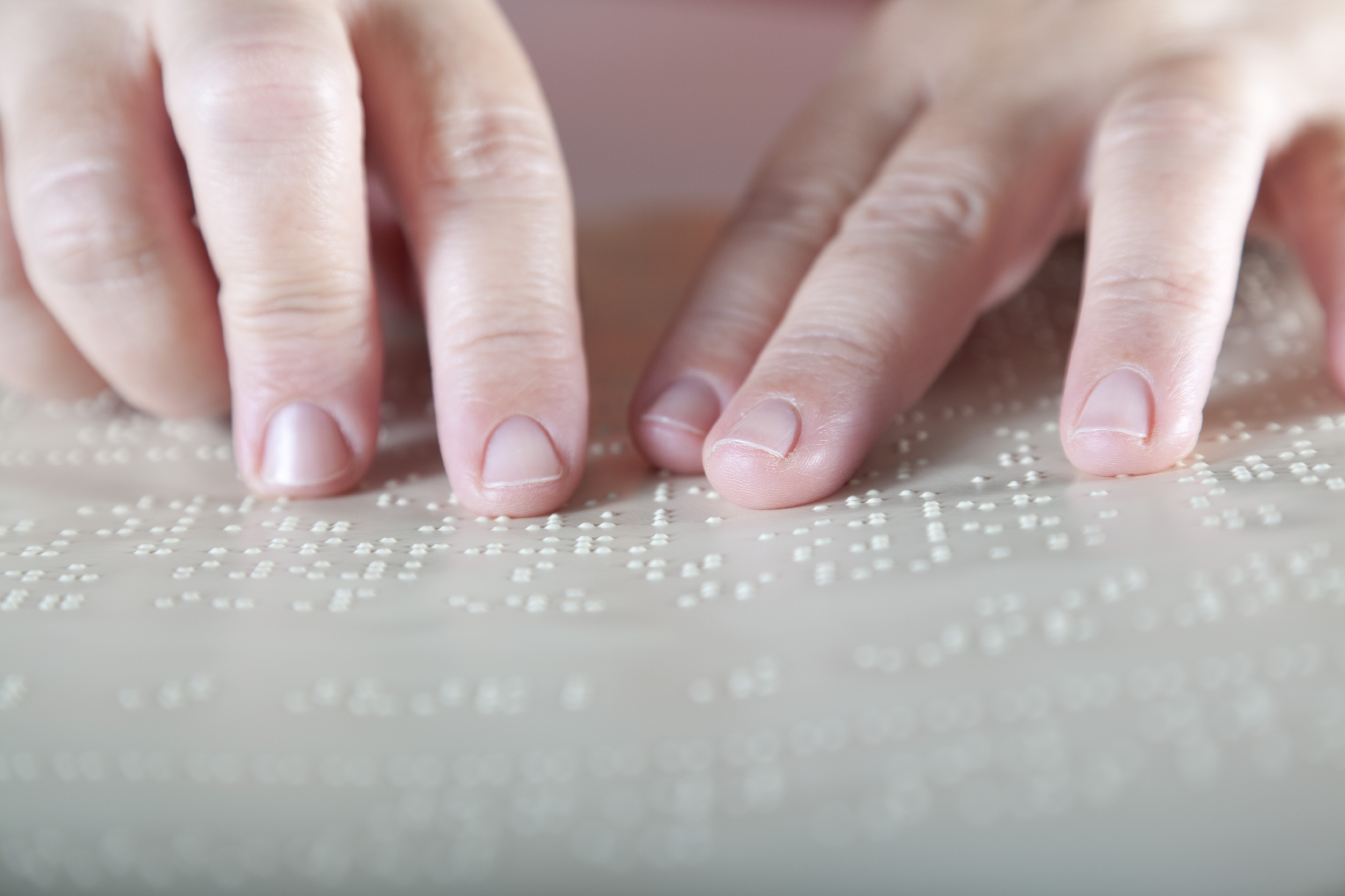 Manos leyendo un texto en Braille